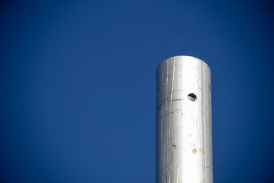 Low angle view of metal against clear blue sky