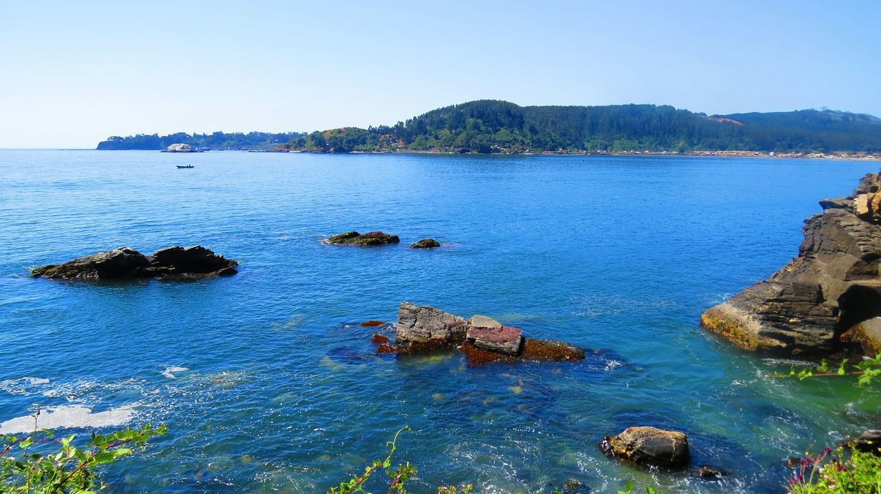 water, sea, nautical vessel, clear sky, blue, tranquil scene, scenics, tranquility, mountain, transportation, beauty in nature, boat, mode of transport, nature, rock - object, horizon over water, copy space, idyllic, coastline, high angle view