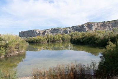 Scenic view of lake against cloudy sky