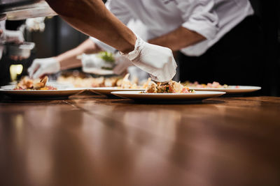 Midsection of man preparing food in restaurant