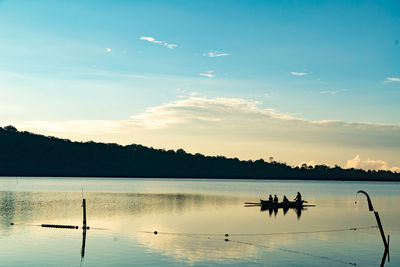 Silhouette boats in lake against sky during sunset