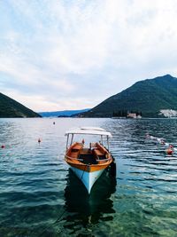 Boat moored in lake against sky