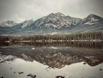 Scenic view of lake and snowcapped mountains against sky