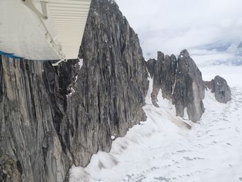 Panoramic view of icicles on rock against sky during winter