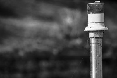 Close-up of pipe on wooden post