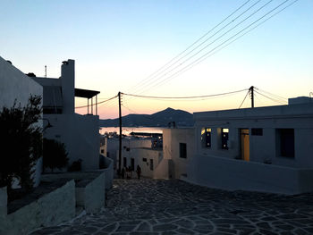 Road amidst buildings against clear sky during winter