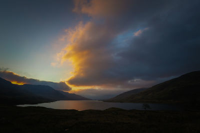 Scenic view of dramatic sky over mountains during sunset