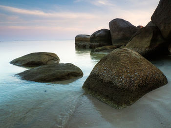 Rocks on sea shore against sky