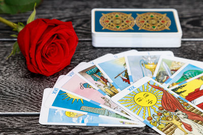 High angle view of tarot cards with rose on table