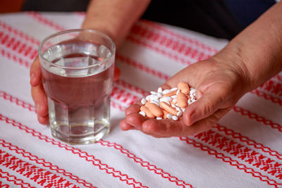 Close-up of hand holding drink on table