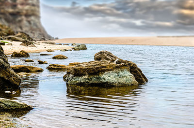 Rock formation in sea against sky