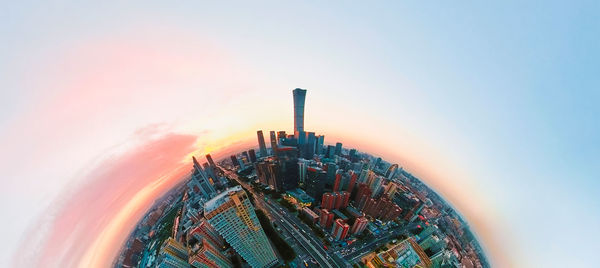 Modern buildings against sky during sunset