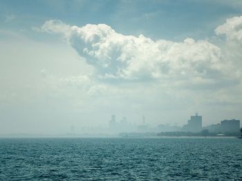View of cityscape against cloudy sky