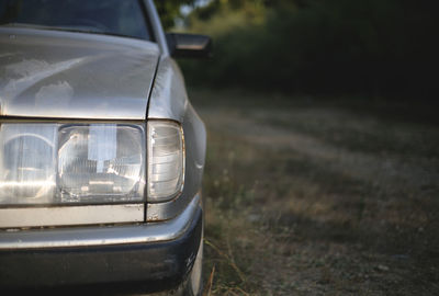 Close-up of abandoned car on field