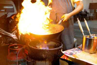 Midsection of man preparing food on barbecue grill