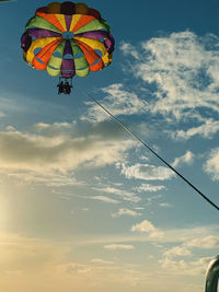 Low angle view of person paragliding against sky