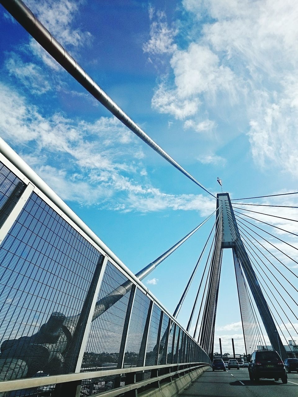 built structure, architecture, low angle view, sky, connection, bridge - man made structure, transportation, engineering, cloud - sky, diminishing perspective, cloud, bridge, metal, railing, the way forward, day, cloudy, modern, suspension bridge, outdoors