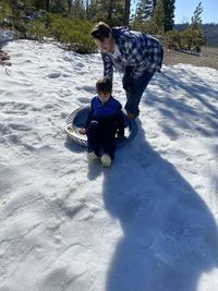 Rear view of father and son on snowcapped during winter