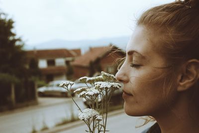 Close-up of young woman smelling flowers