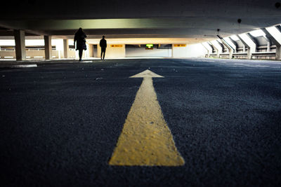 Surface level of man walking on road in parking lot