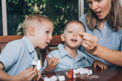 Woman showing glass to sons