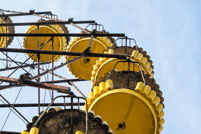 Low angle view of crane at construction site against sky