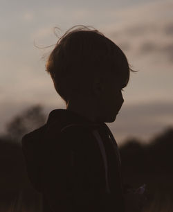 Silhouette boy standing on field