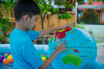 Side view of boy playing with ball