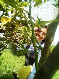 Portrait of smiling young woman with tree