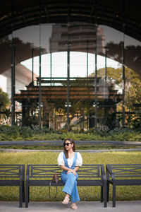 Full length of woman sitting on bench