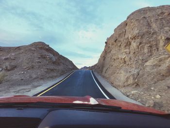 Cars on road against sky seen through car windshield