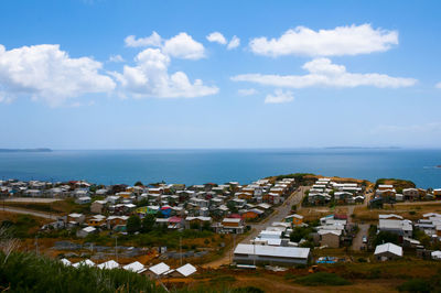 High angle view of townscape by sea against sky