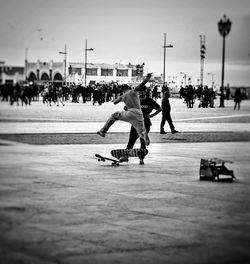 Group of people skateboarding on skateboard against sky