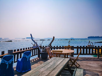 Chairs on beach against clear sky