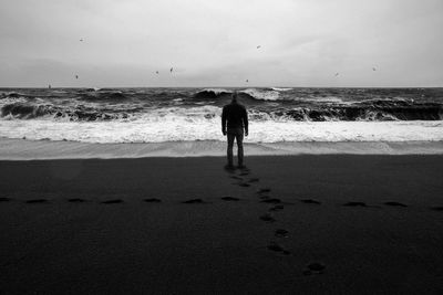 Rear view of man standing on beach