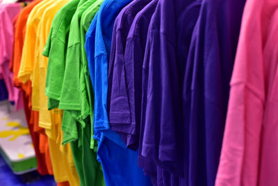 Colorful clothes hanging for sale at store