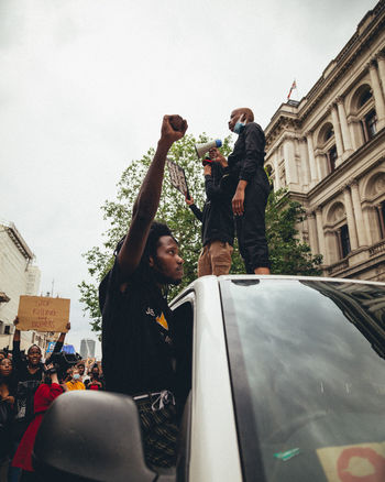 MAN AND WOMAN PHOTOGRAPHING CAR