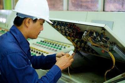 Close-up of man repairing control panel