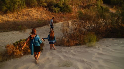 High angle view of people walking on sandy beach