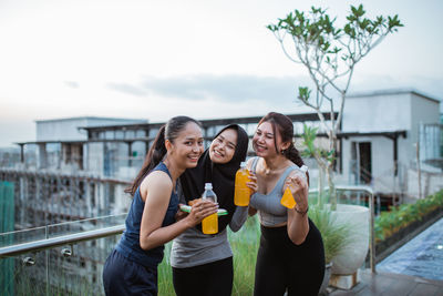 Portrait of smiling friends standing in city