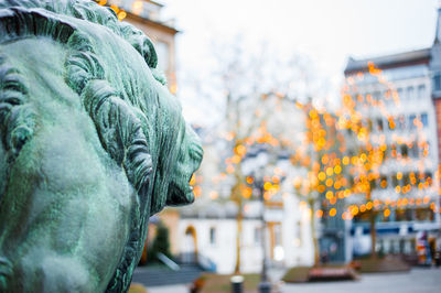 Close-up of statue against buildings in city