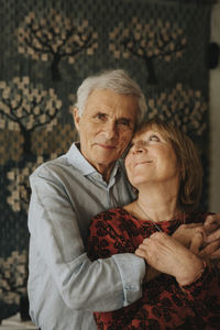 Senior couple hugging at home