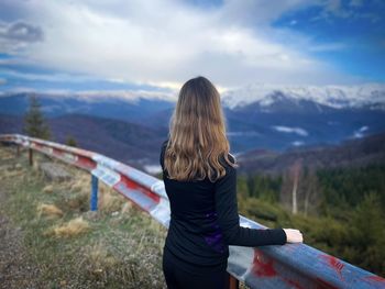 Rear view of woman standing on mountain