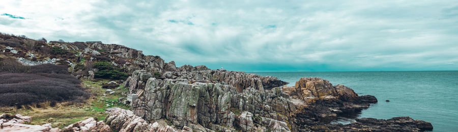 Panoramic view of sea and mountains against sky