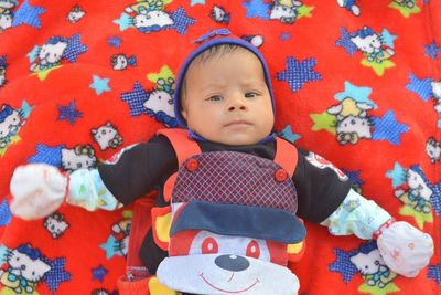 Portrait of cute baby boy lying on bed