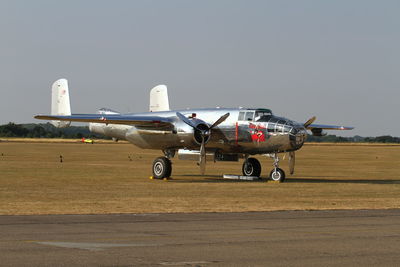 Airplane on airport runway against sky