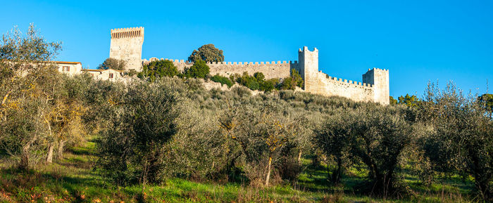 Low angle view of fort against clear blue sky