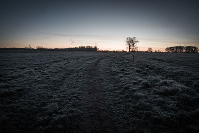 Scenic view of field against sky at sunset