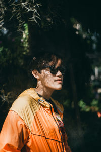 Portrait of woman standing against trees