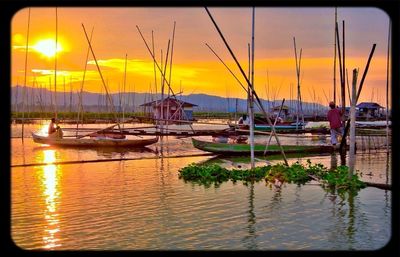 Sailboats in sea at sunset